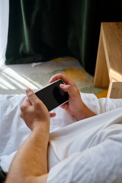 Man Håller Smartphone Sina Händer Sängen Och Kontrollerar Ett Socialt — Stockfoto