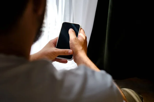Ένας Άνθρωπος Κρατά Ένα Smartphone Στα Χέρια Του Στο Κρεβάτι — Φωτογραφία Αρχείου