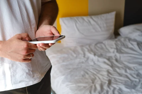 Ένας Άνθρωπος Κρατά Ένα Smartphone Στα Χέρια Του Στο Κρεβάτι — Φωτογραφία Αρχείου
