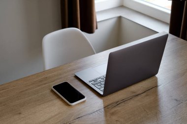 Bilgisayarı ve akıllı telefonu olan bir ofis masası. Birkaç aletli ahşap masa. Uzaktan çalışmak için. Evden çalışıyorum. İş geçmişi. Ofis evde.