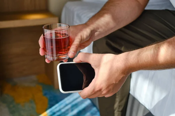 Hombre Mira Pantalla Del Teléfono Sostiene Vaso Cristal Con Alcohol —  Fotos de Stock