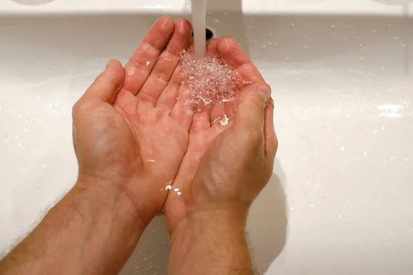 男はバスルームの水で手を洗う 人間の手を閉じる 健康の概念 手をきれいに保つことは感染の広がりを防ぐための最良の方法です — ストック写真