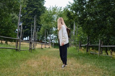 Güzel kız gezgin köyde yürüyor. Kırsal alandaki güzel doğa manzarası. Turist yolunda yürüyüş yapmak. Açık hava macerası. Seyahat ve keşif. Sağlıklı yaşam tarzı