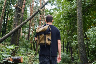 Bir adam ormanda yürür. Ormandaki güzel vahşi doğa manzarası. Turist yolunda yürüyüş yapmak. Açık hava macerası. Seyahat ve keşif. Sağlıklı yaşam tarzı, boş zaman aktiviteleri