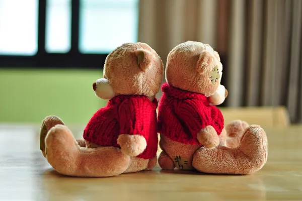 Zwei Teddybären sitzen mit umgedrehtem Rücken. Stockbild