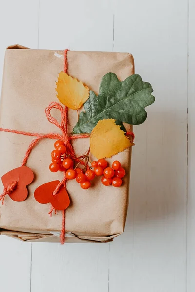 box with autumn gift wrapped in kraft and tied rope with hearts. Eco-friendly biodegradable packaging. DIY Wrapped Thanksgiving Gift