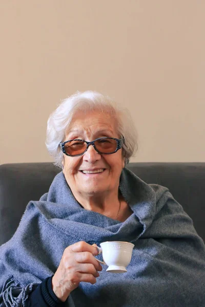 Portret van een oudere vrouw die koffie drinkt. Positieve negentig jaar oude grootmoeder Rechtenvrije Stockfoto's