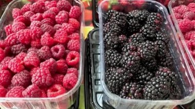 Çiftçi pazarının tezgahında ahududu, çilek ve böğürtlen