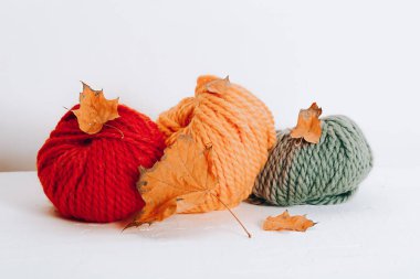 Sonbahar renginde örgü örmek için yün yumakları beyaz arka planda.
