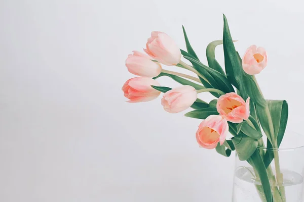 Delicate roze tulpen in een glazen vaas. Scandinavische stijl. Prachtige wenskaart. Het minimale concept. Rechtenvrije Stockafbeeldingen