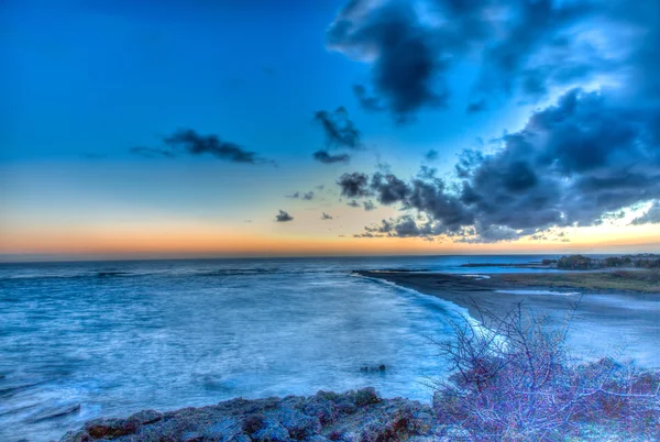 Deep blue glowing sunset over a calm ocean — Stock Photo, Image