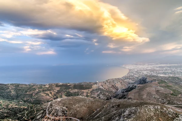 Fiery sun breaking through cloud over the coast — Stock Photo, Image