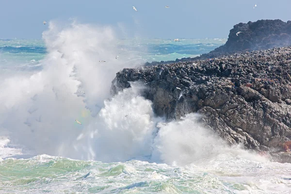 Golven die breken op een rotsachtige kustlijn Stockfoto
