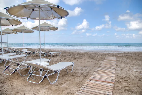 Reposeras y sombrillas en una playa de arena —  Fotos de Stock