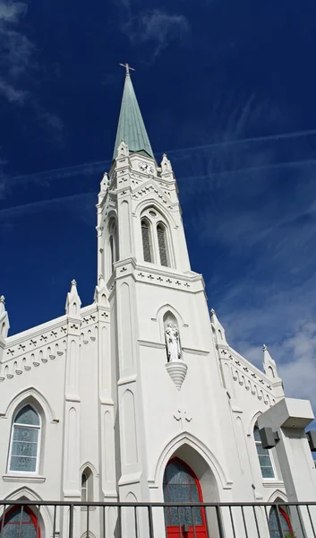 En katolsk kirke mod en blå himmel - Stock-foto