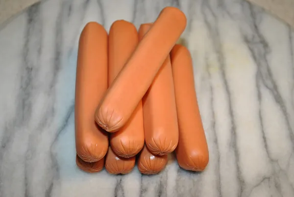 Raw Hotdogs on a Marble Cutting Board — Stok fotoğraf