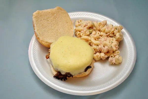 Una hamburguesa con queso y ensalada de macarrones — Foto de Stock