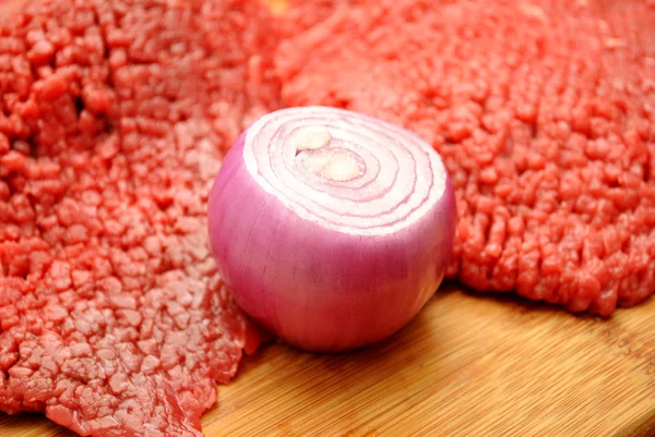 A Raw Red Onion in Front of Fresh Beef — Stock Photo, Image