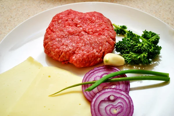 Een ruwe hamburg patty met verse ingrediënten — Stockfoto