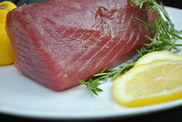 Tonno fresco su un piatto con limoni — Foto Stock