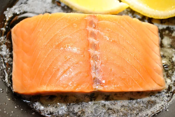 Salmón crudo con mantequilla y limón en una sartén — Foto de Stock