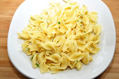 tallarines de huevo con mantequilla en un plato blanco