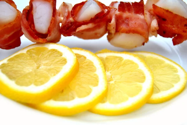 Fatias de limão com vieiras embrulhadas em Bacon — Fotografia de Stock