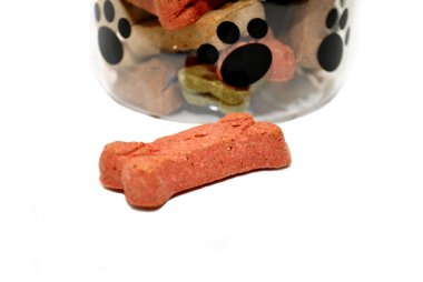 Dog Biscuit in Front of a Jar of Biscuits clipart