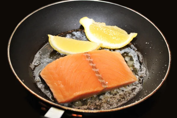 Salmón crudo con mantequilla y limón en una sartén — Foto de Stock