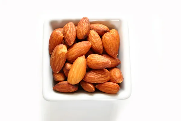 Amandes entières dans un bol carré blanc — Photo