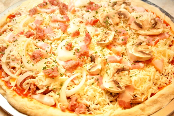 Pizza cruda con champiñones, tocino, cebollas y salchichas — Foto de Stock