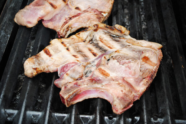 Close-Up of a Juicy Porkchop Cooking on a Grill