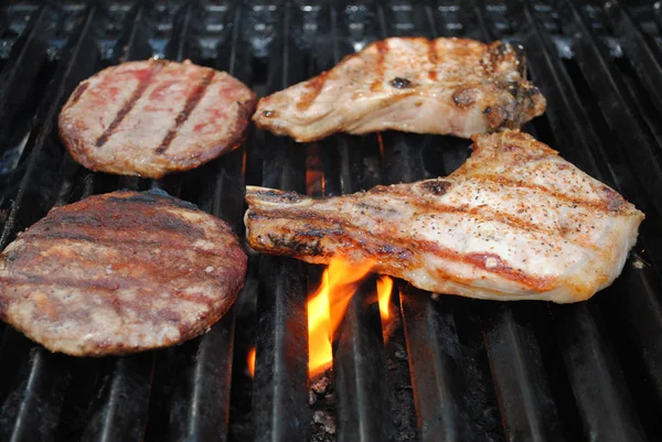 Rund- en varkensvlees op een vlammende grill — Stockfoto