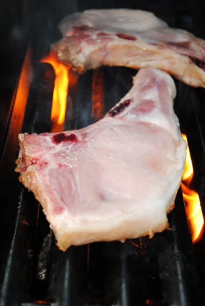 Griller à la flamme une côtelette de porc maigre — Photo