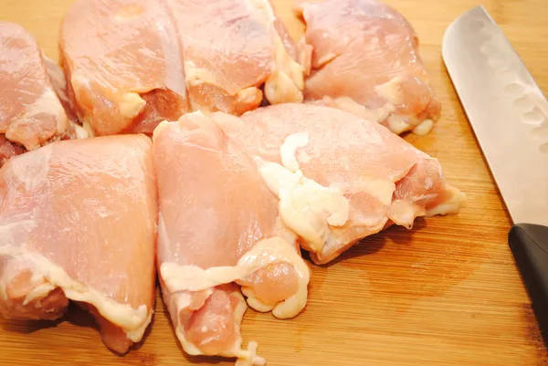 Сырая курица без костей на деревянной доске для резки — стоковое фото