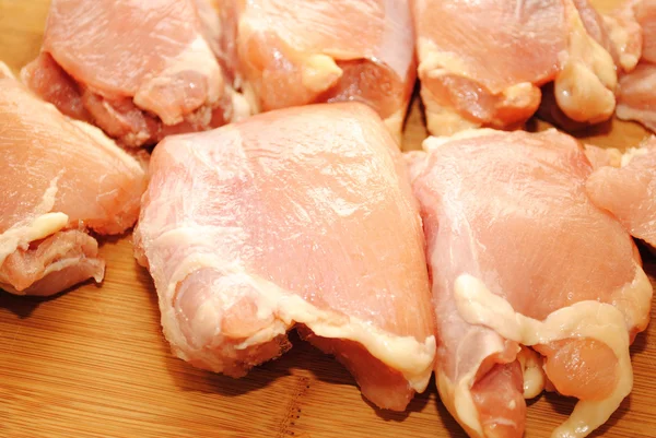 Coxas de frango desossadas cruas em uma placa de corte — Fotografia de Stock