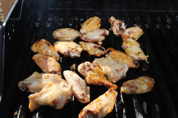 Pezzi di pollo alla griglia su una griglia calda — Foto Stock