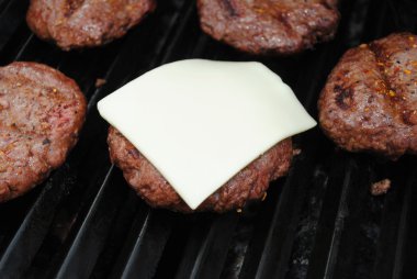 Close-Up of American Cheese Melting on a Beef Burger clipart
