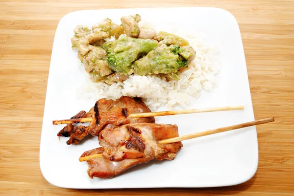 Un repas de poulet sur un bâton et de poulet avec du brocoli — Photo