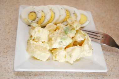 Patates salatası ve bir tabağa dilimlenmiş yumurta