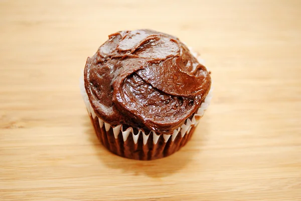 Ein Schokoladenkuchen mit Zuckerguss auf Holz — Stockfoto