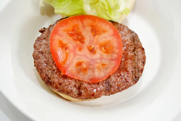 Hambúrguer grelhado fresco com tomate fatiado — Fotografia de Stock
