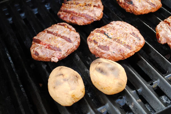 Two Whole Potatoes and Bugers on a Summer Grill — Stock Photo, Image