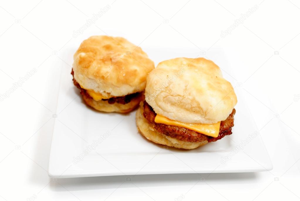 Two Sausage Sandwiches on a White Plate