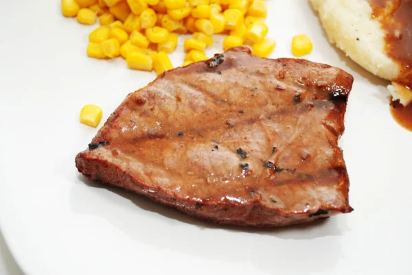 Steak servi sur une assiette avec des côtés — Photo