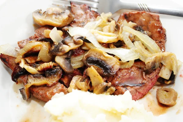 Kızarmış yağlı mantar ve soğan ile servis biftek — Stok fotoğraf