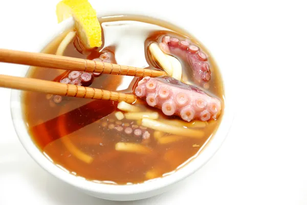 Bläckfisk och äta Nudel soppa med pinnar — Stockfoto