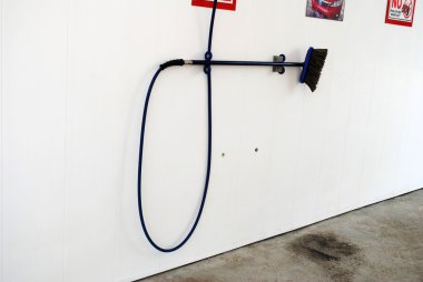 bir duvarda asılı Oto yıkama hortumu