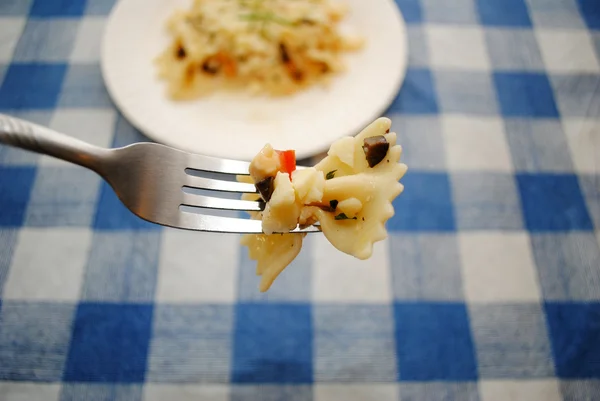 Pasta Bowtie en un tenedor con verduras picadas — Foto de Stock