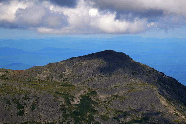 Wolken über einem hohen Berggipfel — Stockfoto